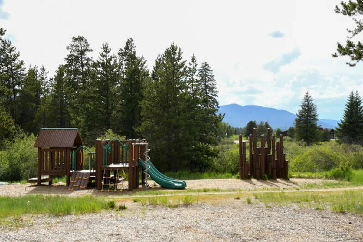 A vibrant playground structure set outdoors, with slides and climbing features inviting family fun. The surrounding area suggests community amenities and opportunities for children and families to play together.