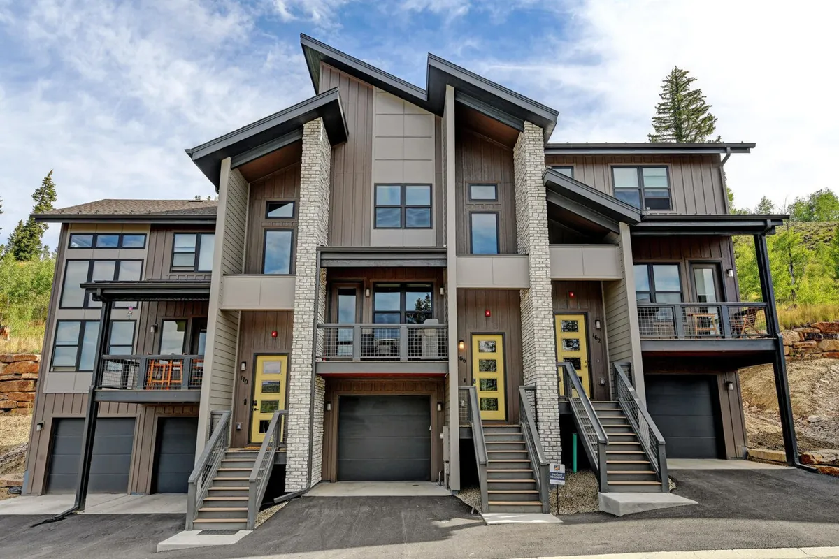 The image showcases the modern exterior of the property, featuring inviting balconies and multiple staircases. The scene is set for family gatherings or relaxed evenings outdoors, with sunset lighting hinting at a peaceful, welcoming environment.