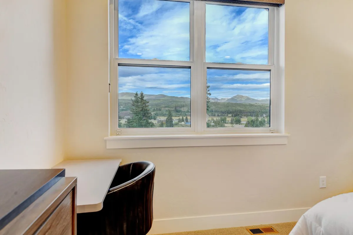 A serene corner with a desk and chair positioned beside a window, offering a peaceful spot for work or reflection while enjoying views of the outdoors. The setting is filled with soft, natural light, ideal for focused or creative pursuits.